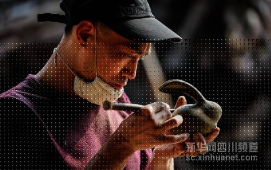 4月18日，工艺师在芦山县天功根意金丝楠乌木艺术馆里制作乌木根雕作品。