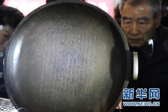 11月7日，游客在艺博会上参观回流后首次在国内公开展出的国宝级珍品“兮甲盘”。 新华社记者 郝同前 摄