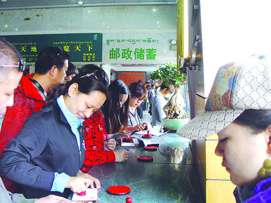 邮人在明信片上加盖纪念戳。