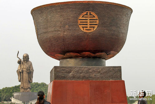 10月28日，参观者在江苏如皋市观看“青铜万寿百岁碗”，远处是总高49米的铜质巨型雕像“天下第一大寿星”。新华网图片 许丛军 摄