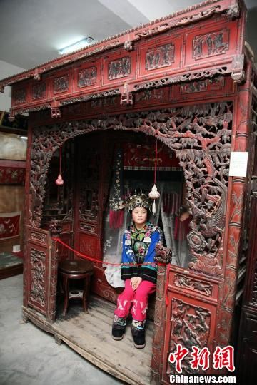 一位苗家姑娘坐在双凤秀女床上。杨华峰 摄