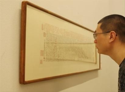一名参观者在“冯其庸九十诗?书?画展”上欣赏展出作品