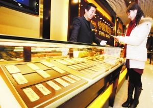 受国际黄金价格波动影响，昨日，菜百、国华等金店黄金价格纷纷下调，足金价格从405元/克下调至395元/克，千足金价格从408元/克下调至398元/克。 北京商报记者 暴帆/文并摄
